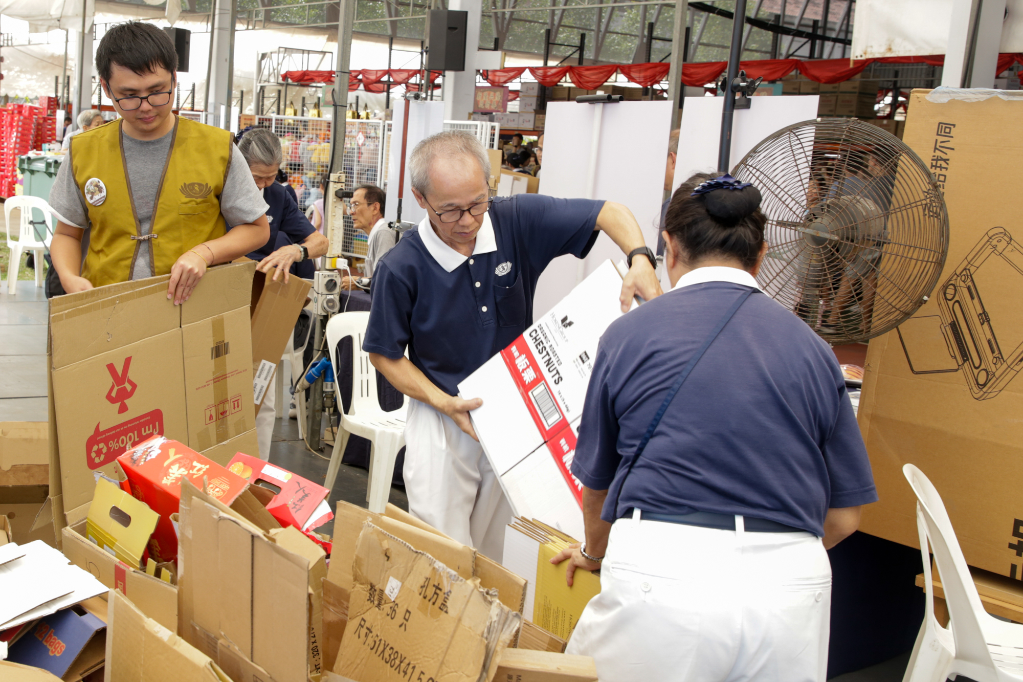 志工们齐心协力整理回收的纸箱。摄/ 冯桂琼