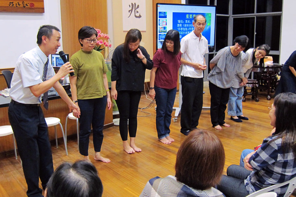 为了呈现“TC”、“52”和两尊飞天菩萨的队形，加入队形的志工和民众需分别穿上白色或黑色上衣，志工详细说明服仪的默契。摄 / 林翠莲