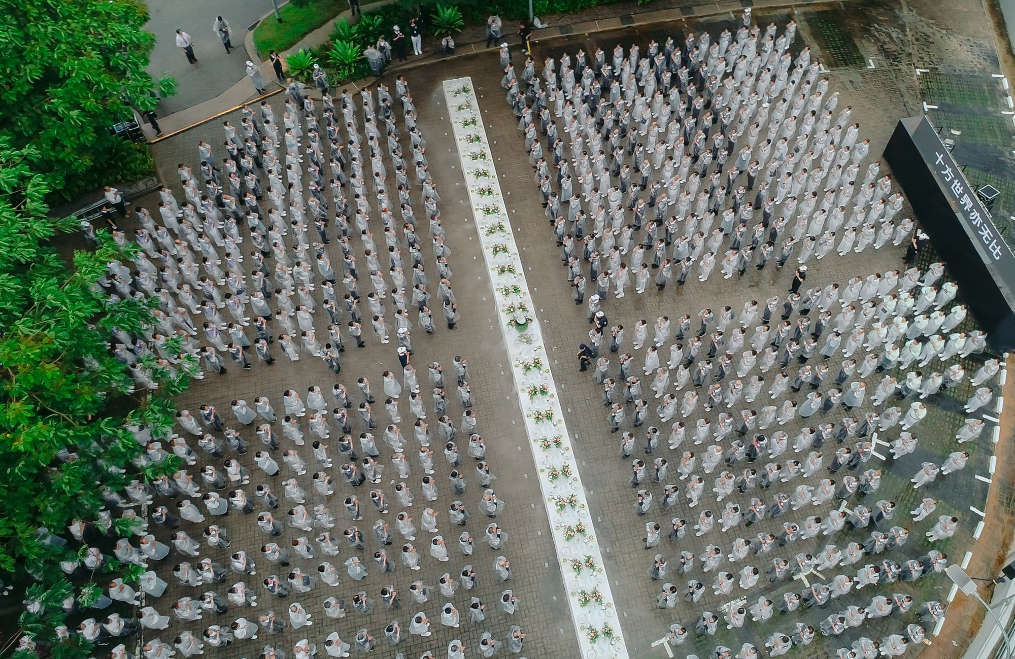 791名慈济人披上雨衣，在静思堂旁的停车场组成灰蓝相间的法水涟漪队形。（摄/空拍截屏）